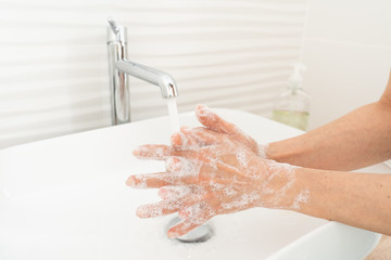 Wall Mural - Woman washing her hands in bathroom