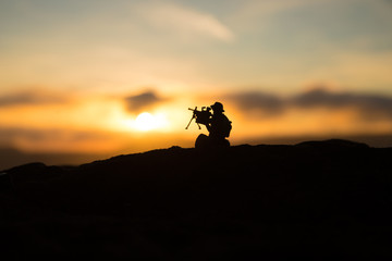 War Concept. Military silhouettes fighting scene on war fog sky background, World War Soldiers Silhouette Below Cloudy Skyline At sunset.