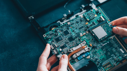 Microelectronics engineering. Computer diagnostics. Technician examining motherboard.