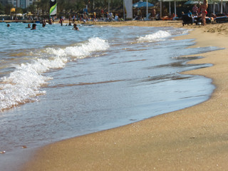 Waves smoothly envelop the sandy shore