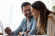 © fizkes - Happy loving couple using laptop together, holding hands, looking at screen, smiling wife and husband having fun with computer, watching video or movie, shopping online, reading good news in message