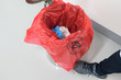 © arcyto - Close up scientist foot and red bag with bioharzard sign.Worker foot pushing red garbage bag.Maid and infection waste bin at the indoor public building.Infectious control.