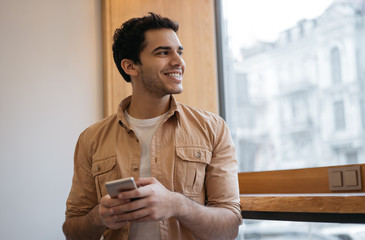 successful indian man using smart phone with mobile app for ordering food online on website. happy a