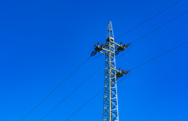 Power line pole (medium voltage network) against the blue sky.