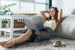 © undrey - Young woman is relaxing and using laptop at home