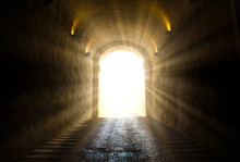 A Bright Yellow Glowing Light Breaking Through At The End Of A Dark Tunnel
