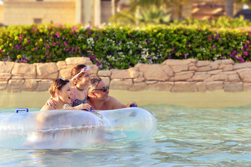 Canvas Print - Happy Dad, mother and daughter relax in the pool