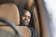 African businessman sitting in a car in the back seat view through the windshield