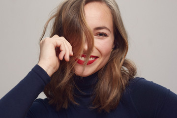 portrait of a cute happy girl with a big smile on her face and hair in front of her head