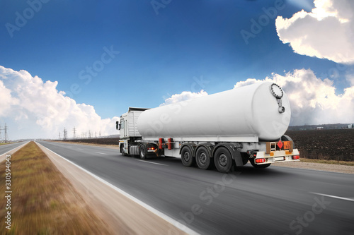 Fotografía Big fuel tanker truck shipping fuel on the countryside road in motion against sk