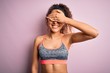 © Krakenimages.com - Beautiful sportswoman with curly hair doing sport wearing sportswear over pink background smiling and laughing with hand on face covering eyes for surprise. Blind concept.