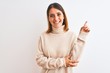 © Krakenimages.com - Beautiful redhead woman wearing winter turtleneck sweater over isolated background with a big smile on face, pointing with hand and finger to the side looking at the camera.