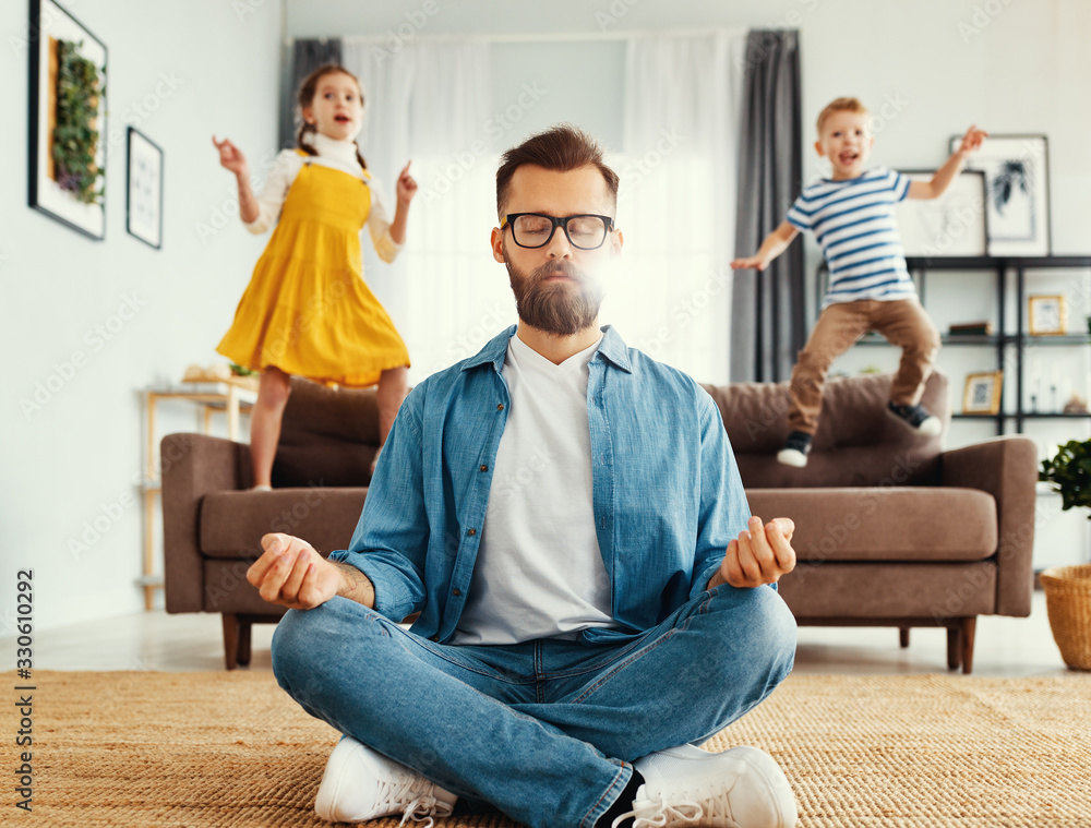 Father meditating in room with playful kids - obrazy, fototapety, plakaty 