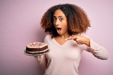 Young African American Woman With Afro Hair Holding Delicious Birthday Cake Very Happy Pointing With Hand And Finger