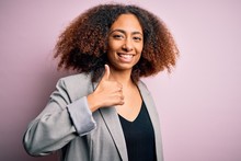 Young African American Businesswoman With Afro Hair Wearing Elegant Jacket Doing Happy Thumbs Up Gesture With Hand. Approving Expression Looking At The Camera Showing Success.