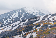 Aspen, Colorado USA Buttermilk Ski Slope Hill In Rocky Mountains View Of Storm Clouds And Peak With Snow On Yellow Foliage Autumn Trees
