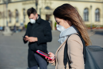 Woman and guy in a masks using mobile phone