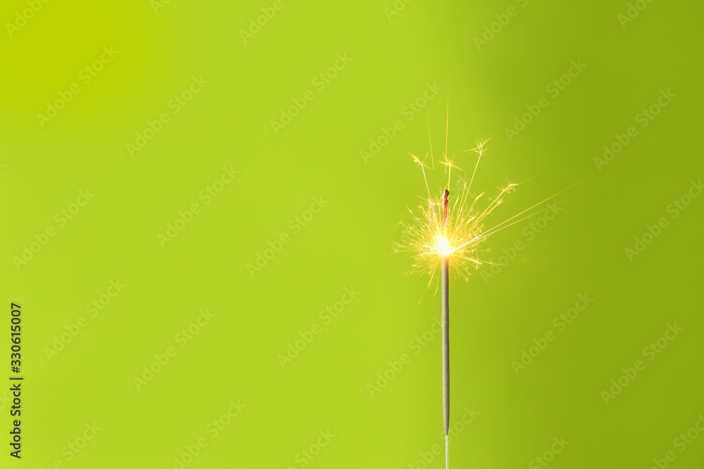 Beautiful Christmas sparkler on color background