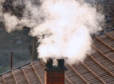 Fototapeta  - Smoke from the chimney to the roof
