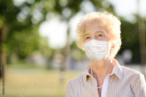 Fotomural Outdoors portrait senior woman wearing disposable medical face mask