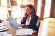 © Krakenimages.com - Middle age beautiful businesswoman smiling happy and confident. Sitting on chair working in a desk talking by smartphone at the office