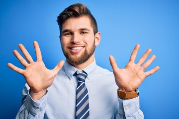 Young blond businessman with beard and blue eyes wearing elegant shirt and tie standing showing and pointing up with fingers number ten while smiling confident and happy.