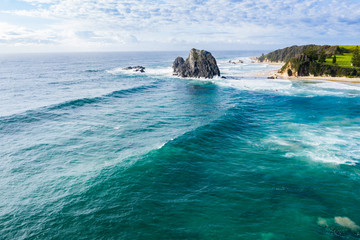 Aerial drone view of Glasshouse Rocks at Narooma Beach in Narooma on the New South Wales South Coast, Australia, on a sunny day  