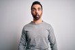 © Krakenimages.com - Young handsome man with beard wearing casual sweater standing over white background making fish face with lips, crazy and comical gesture. Funny expression.