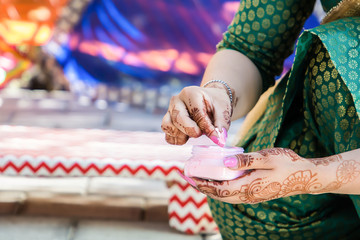 Indian pre wedding haldi turmeric ceremony ritual items and hands close up