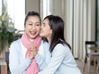 © xreflex - Happy Asian family, Daughter embracing her mother and kiss cheeks with love in home. happy mother's day
