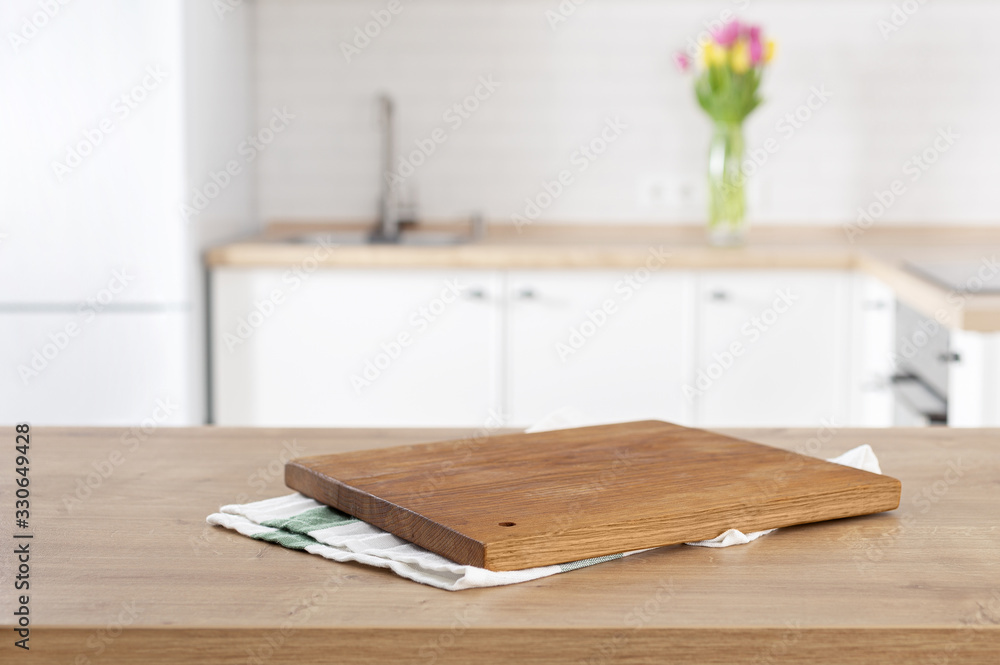 kitchen cutting board on the kitchen table top on blur kitchen background with place for montage product display - obrazy, fototapety, plakaty 