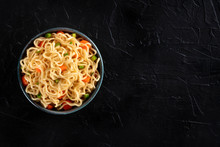 Instant Noodles Bowl With Carrot And Scallions, Shot From Above On A Black Background With A Place For Text