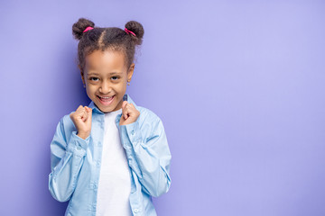 happy   african child girl isolated over purple background. emotional cheerful little girl with excited expression face, she is waiting for surprise on her birthday. happiness concept