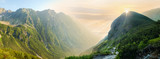 Fototapeta  - Deep mountain valley in morning sunlight, panoramic view