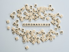 Coronavirus covid19 spelt on scrabble tiles and surrounded by other tiles 