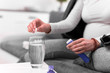 © astrosystem - Pregnant woman taking vitamin tablet in a glass of water.