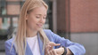 © stockbakers - Young Businesswoman Using Smartwatch Outdoor