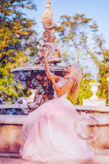 Beautiful woman with bubbles in park