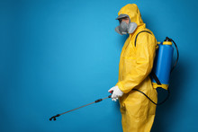 Man Wearing Protective Suit With Insecticide Sprayer On Blue Background, Space For Text. Pest Control