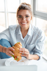 Wall Mural - Smiling young businesswoman having lunch