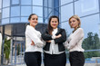 © RomanR - Three managers with folders posing outside office building
