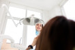 © Andrii  - Satisfied dentistry patient woman looks in the mirror at the result of dental treatment