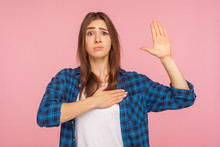 I Swear, It's True! Portrait Of Girl In Checkered Shirt Trying To Look Honest With Funny Grimace, Keeping Hand On Chest And Giving Promise To Tell Truth. Indoor Studio Shot Isolated On Pink Background