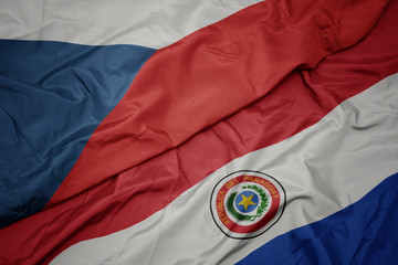 waving colorful flag of paraguay and national flag of czech republic.