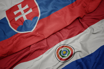 waving colorful flag of paraguay and national flag of slovakia.