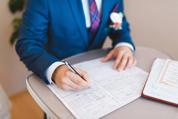 Wall Mural - groom signing wedding certificate