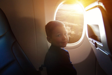 little boy in airplane seat by window