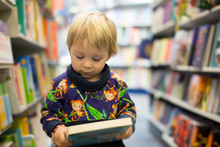 Adorable Little Boy, Sitting In A Book Store