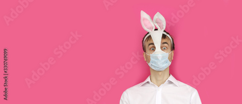 banner with frightened man in mask Easter Bunny and medical mask look ahead, virus or coronavirus protection holiday