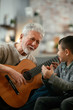 © JustLife - Grandpa and grandson playing guitar.